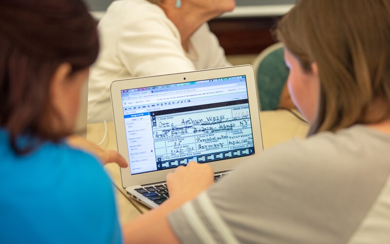 Dos mujeres que miran en FamilySearch.org la interfaz de la indexación en línea.