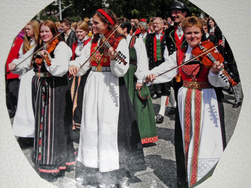 Norwegians wearing traditional Norwegian dress and playing violins