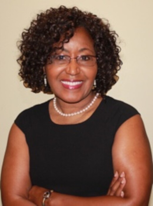Bernice Bennett is smiling wearing a black dress, pearls, and glasses.