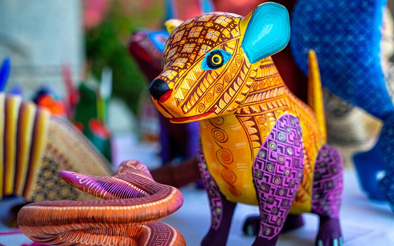 A colorful sculpture of an animal, known as an alebrijes, a colorful tradition of Mexico